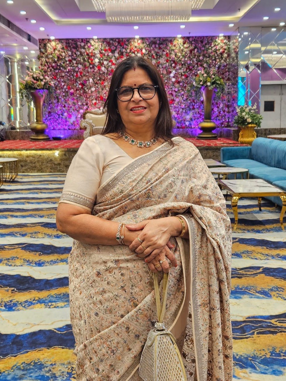 Santosh in an ivory saree with an emerald necklace